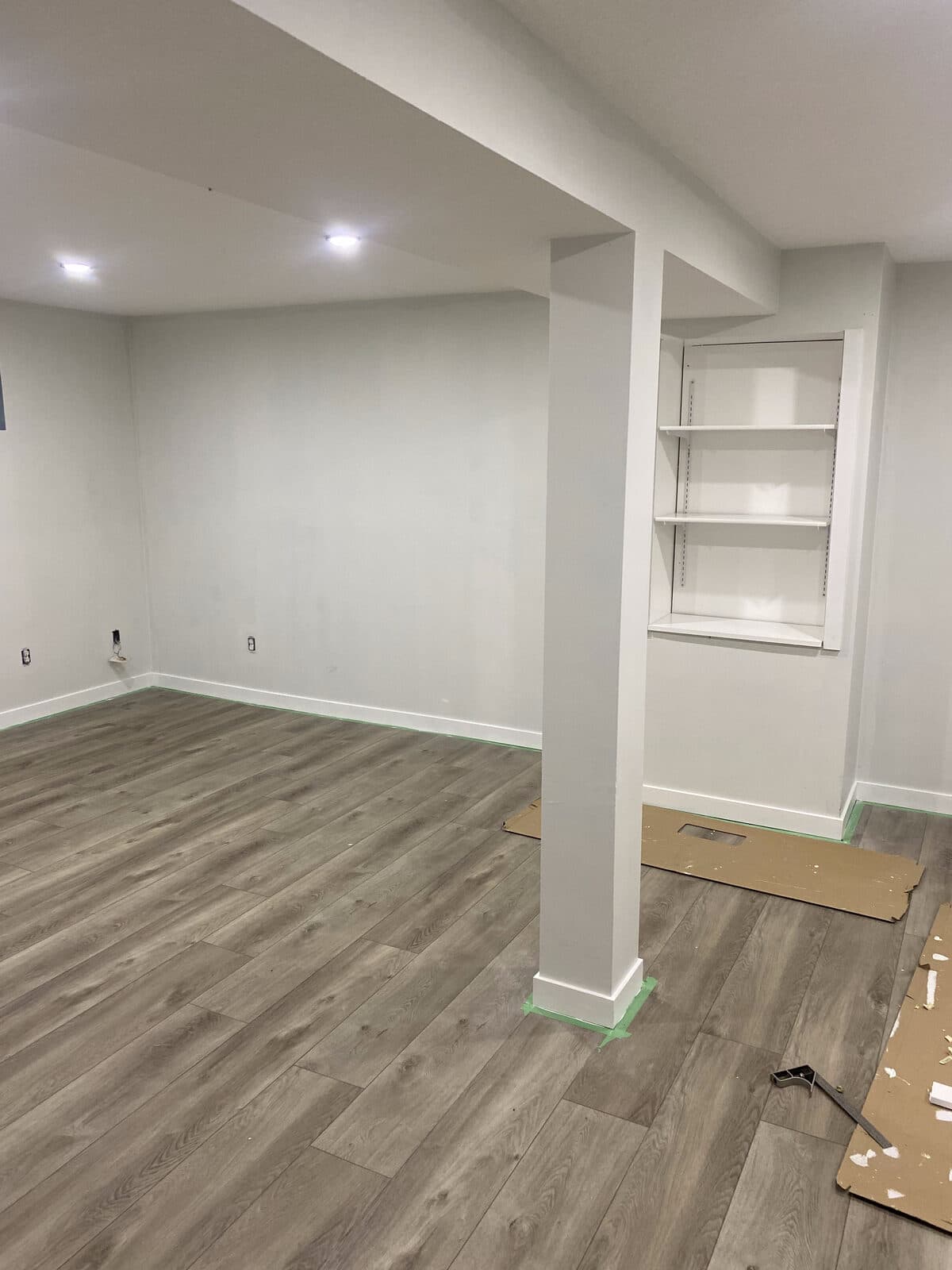 Finished basement living space with vinyl plank flooring and recessed lighting — JFK Surfaces Central Alberta