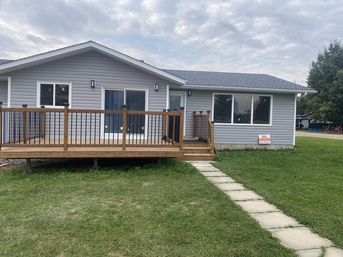 Finished home exterior with fence and deck — JFK Surfaces in Central Alberta