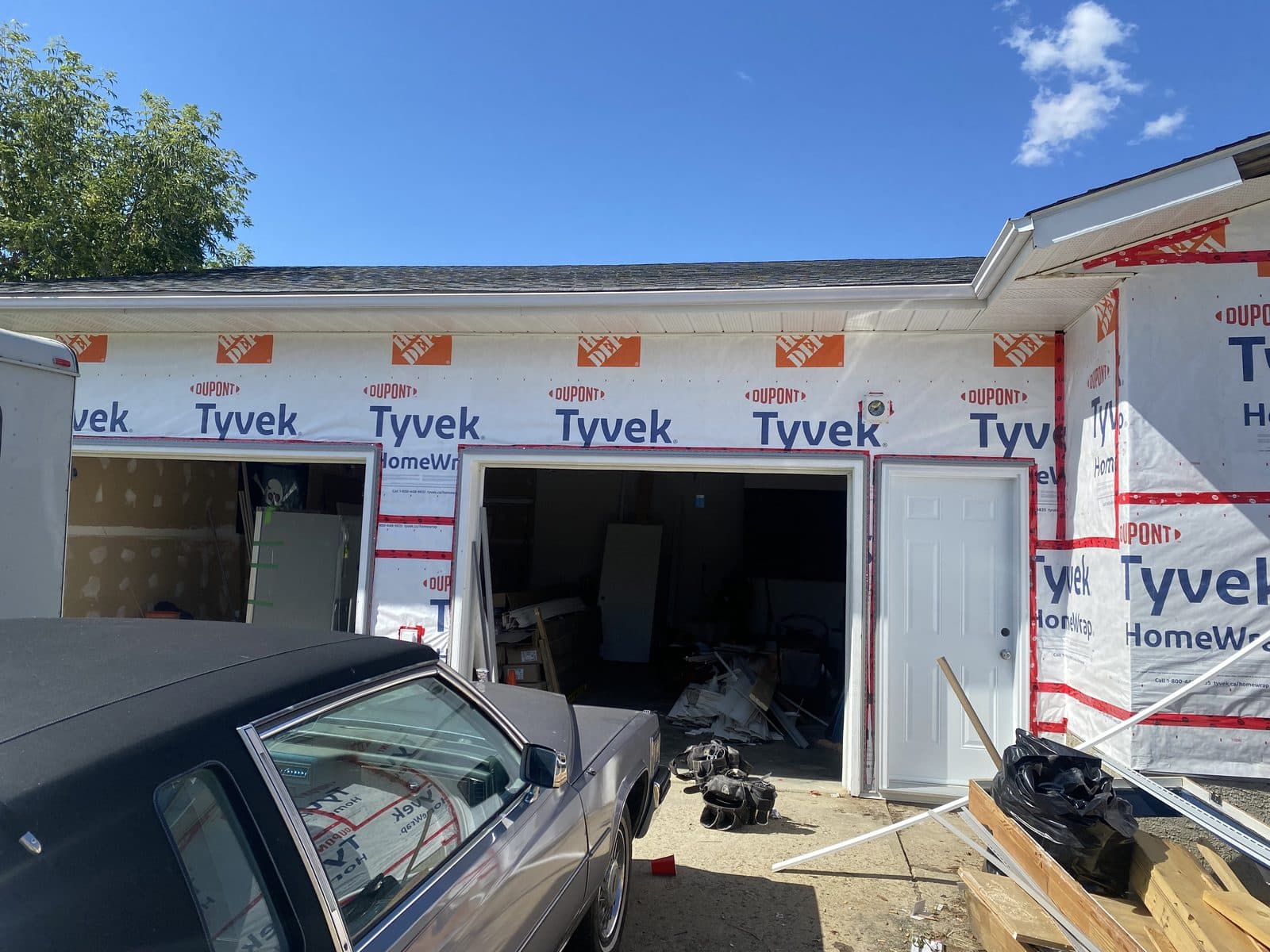 Attached double-bay — Tyvek stage — JFK Surfaces project in Central Alberta