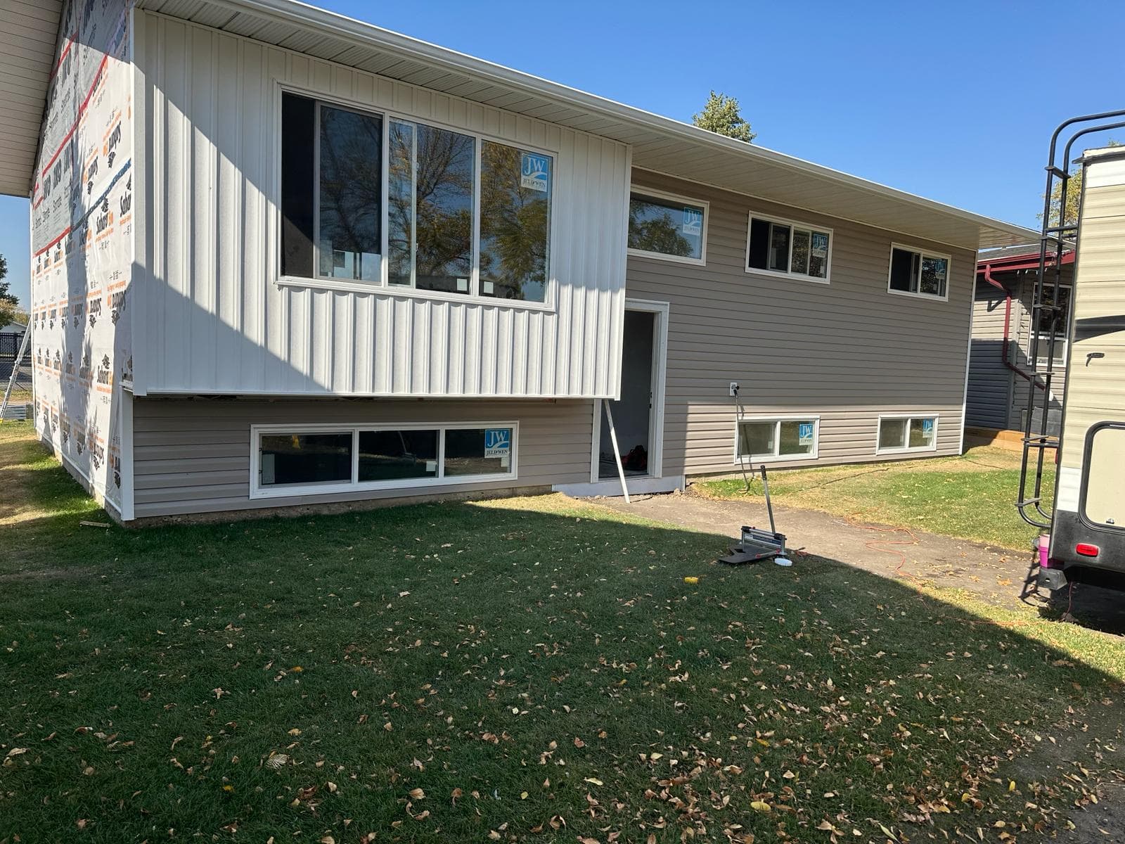 Bi-level home with new vinyl siding being installed — JFK Surfaces in Central Alberta